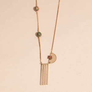asymmetrical, brass box chain, three unakite beads, semi-circle with unakite square, four prong, brass pendant on bottom.