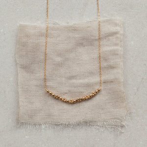 gold chain necklace with round gold beads, asymmetrical